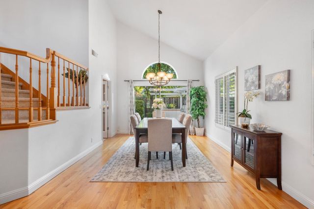 a dining room with furniture a chandelier and wooden floor