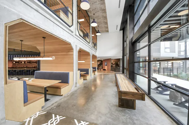 a living room with furniture a flat screen tv and a floor to ceiling window