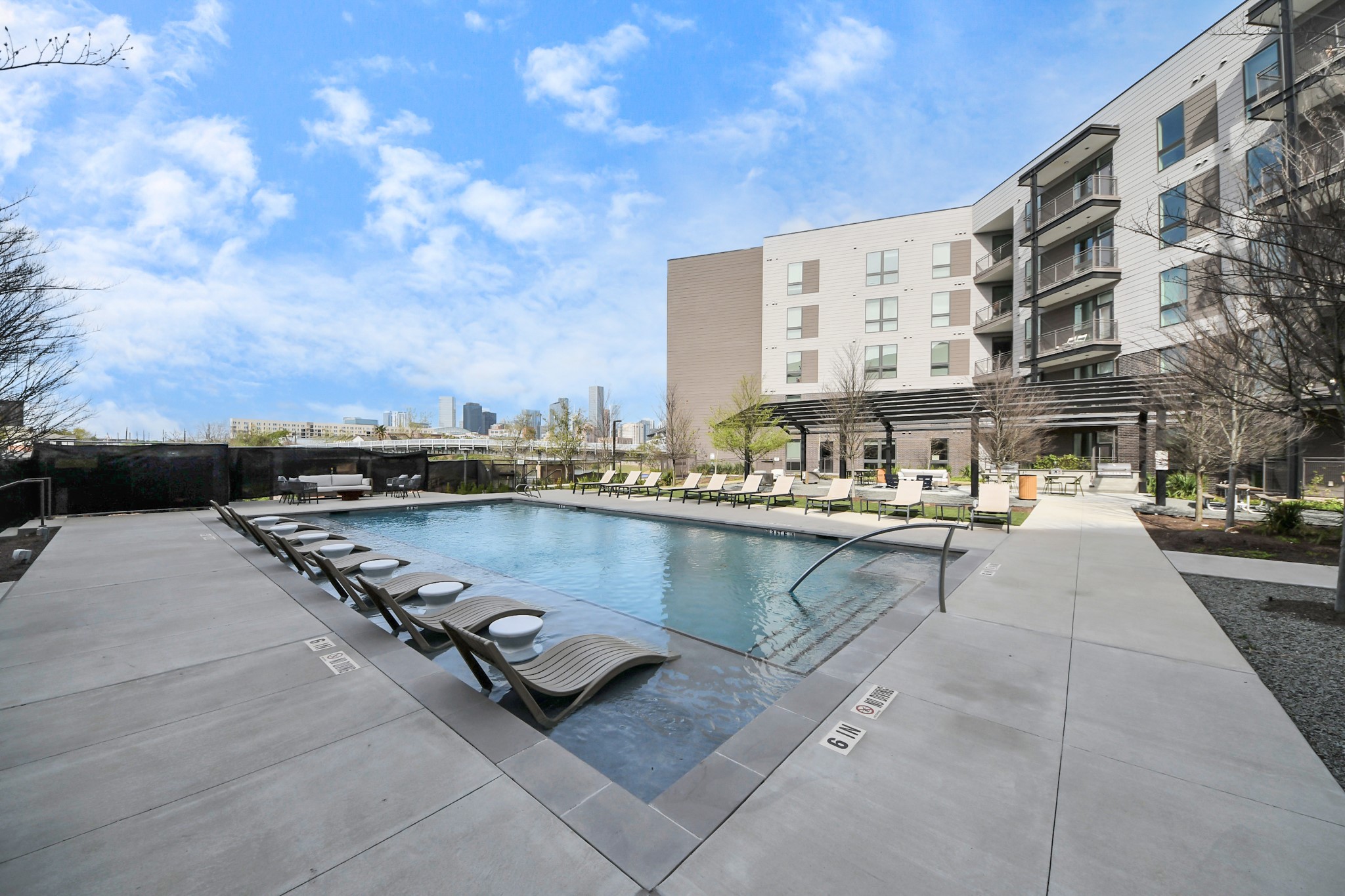 2810 Riverby Road, Unit 263 Houston, TX 77020 - Photo 31 of 38 a swimming pool with outdoor seating and buildings in the background