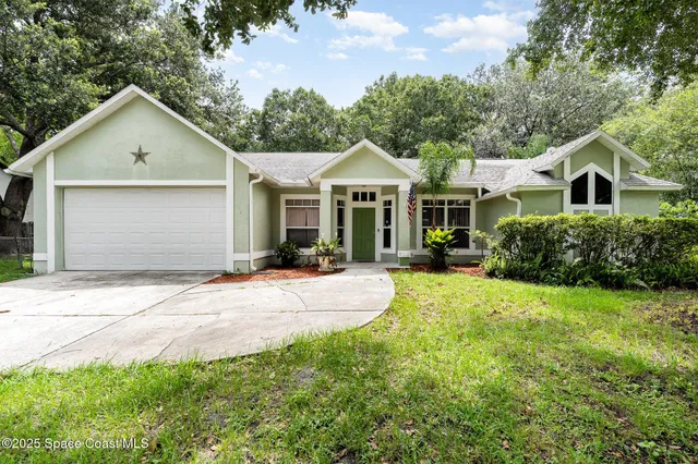 a front view of a house with a yard and trees