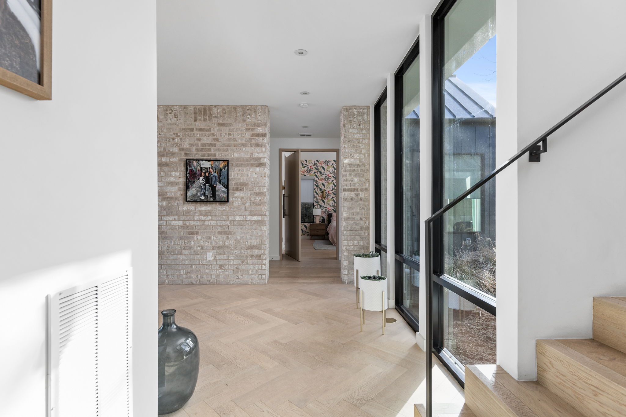 7502 St Louis Street Austin, TX 78757 - Photo 4 of 38 Hallway featuring expansive windows, parquet flooring, and brick wall