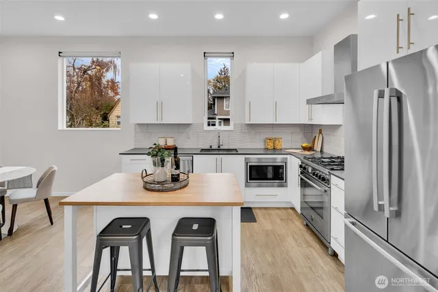 a kitchen with stainless steel appliances granite countertop a refrigerator and a stove top oven