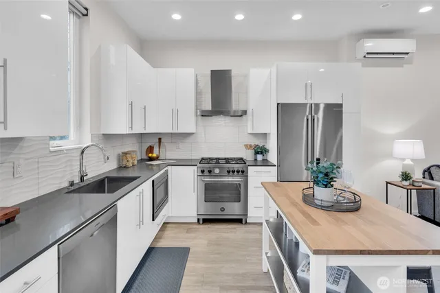 a kitchen with stainless steel appliances a sink stove refrigerator and cabinets