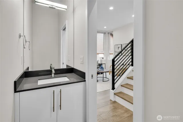 a kitchen with a sink a refrigerator and wooden floor