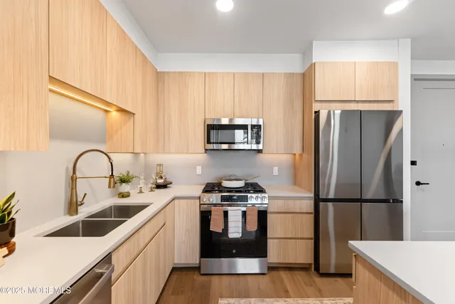 a kitchen with stainless steel appliances a refrigerator stove and sink