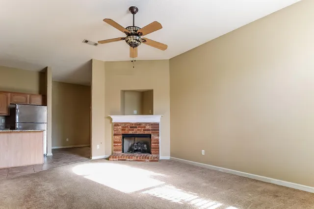 a view of a livingroom with a fireplace and a ceiling fan