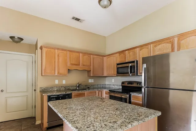 a kitchen with a refrigerator a microwave a sink and a stove