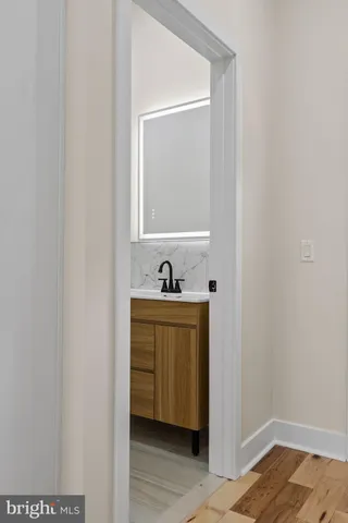 a view of bathroom with sink mirror and window