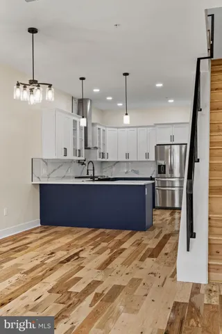 a kitchen with kitchen island granite countertop a sink refrigerator and cabinets
