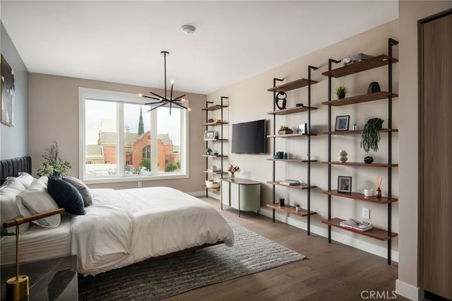 a bedroom with a large bed and a flat tv screen