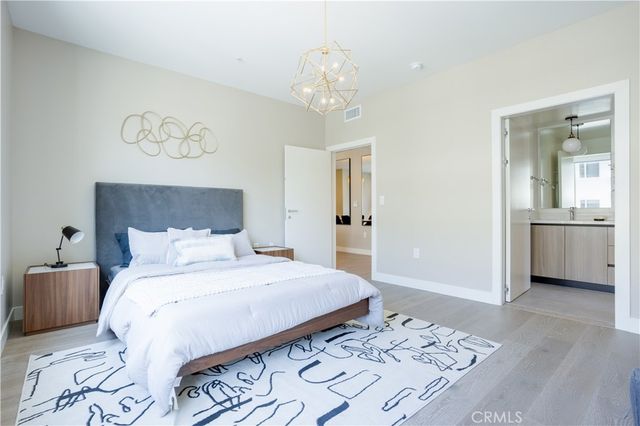 a bedroom with a large bed and a chandelier