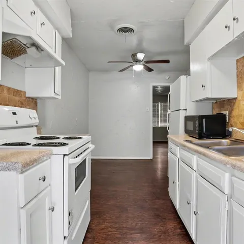 a kitchen with a stove and a white cabinets