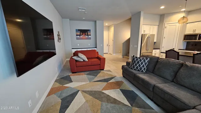 a living room with furniture a flat screen tv and a couch