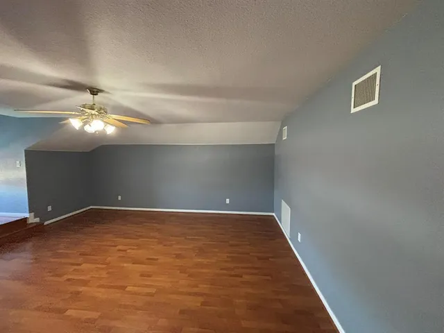 a view of an empty room with a chandelier fan