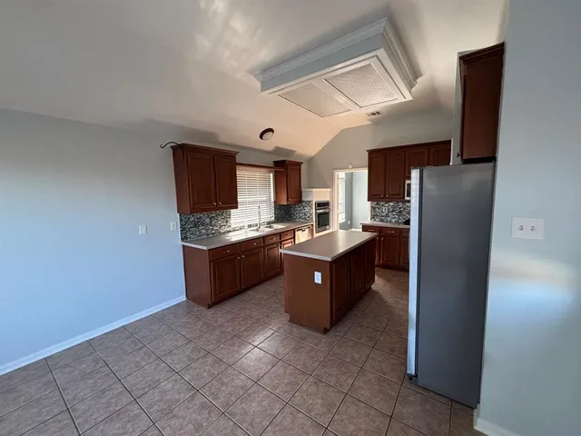 a kitchen with stainless steel appliances granite countertop a refrigerator and a stove