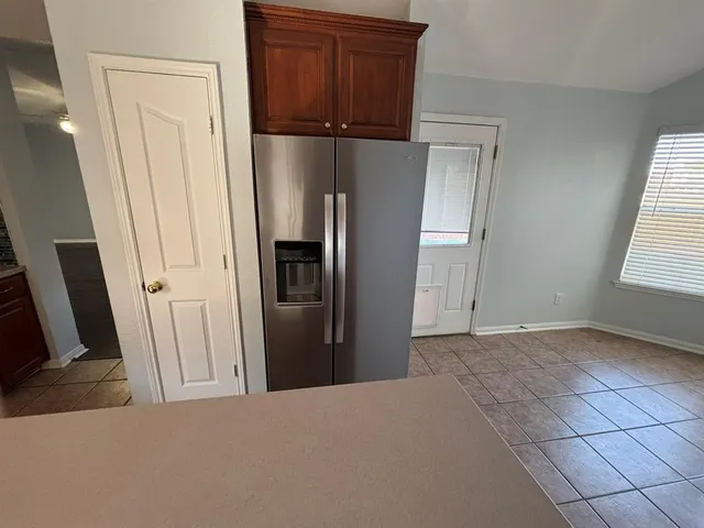 a view of hallway with window and refrigerator