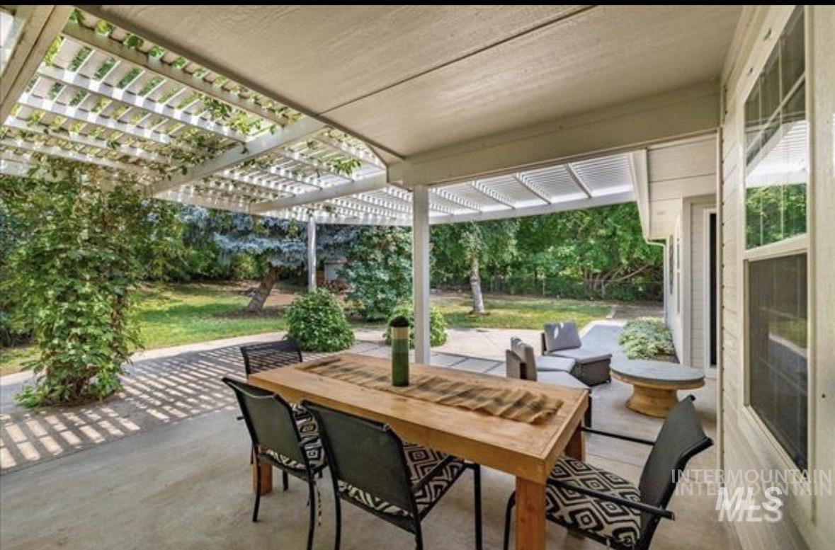 6600 East Victory Road Nampa, ID 83687 - Photo 16 of 19 Expansive concrete patio featuring a white pergola with established vines, providing dappled sunlight
