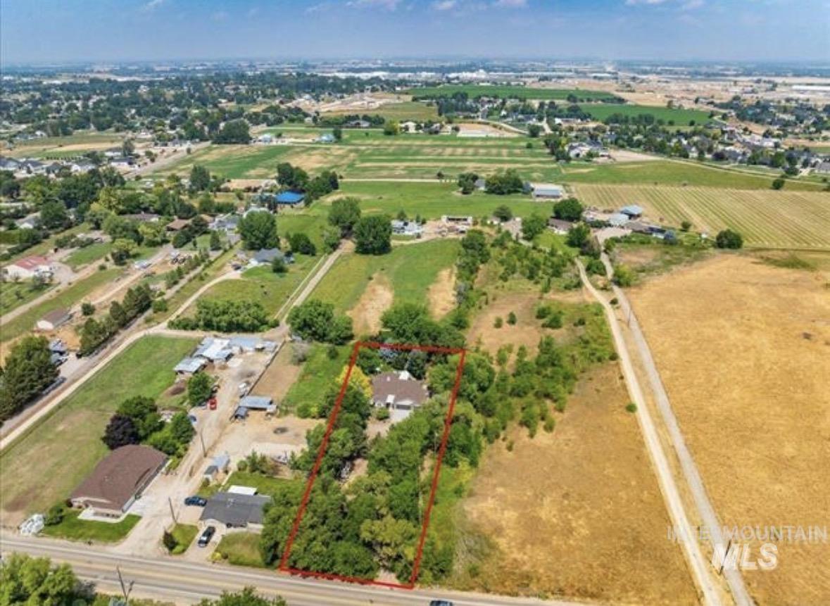 6600 East Victory Road Nampa, ID 83687 - Photo 2 of 19 Aerial view showcasing a residential property with surrounding mature trees, offering a distinct boundary