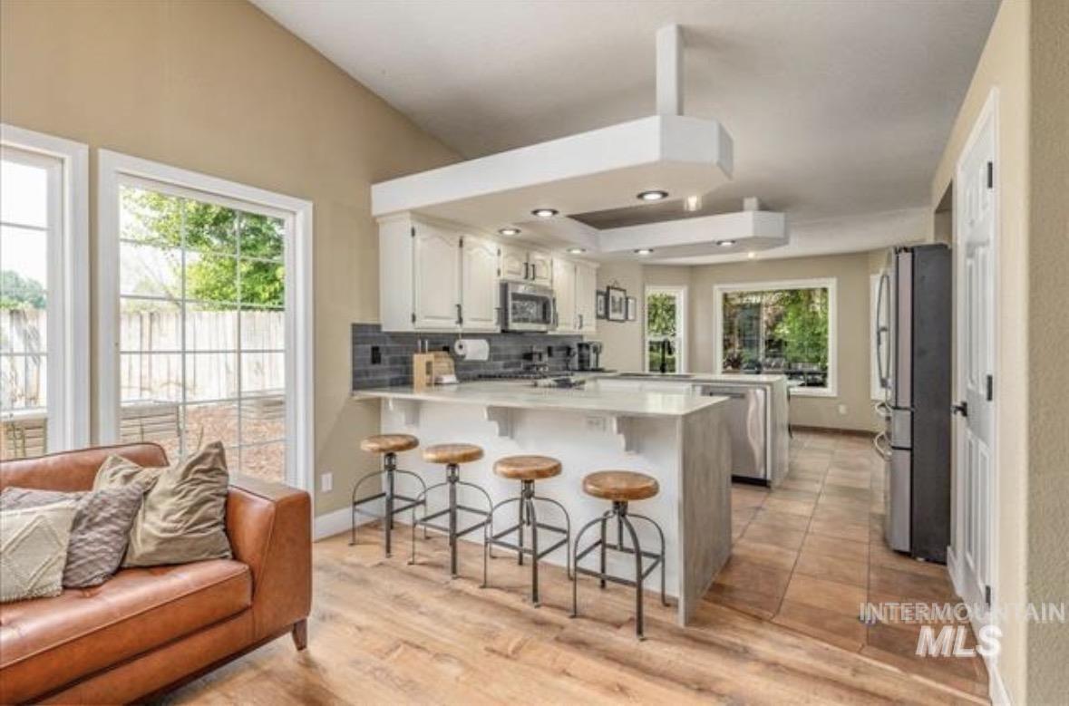 6600 East Victory Road Nampa, ID 83687 - Photo 7 of 19 Open-concept kitchen and living area featuring a vaulted ceiling and wood-finish flooring