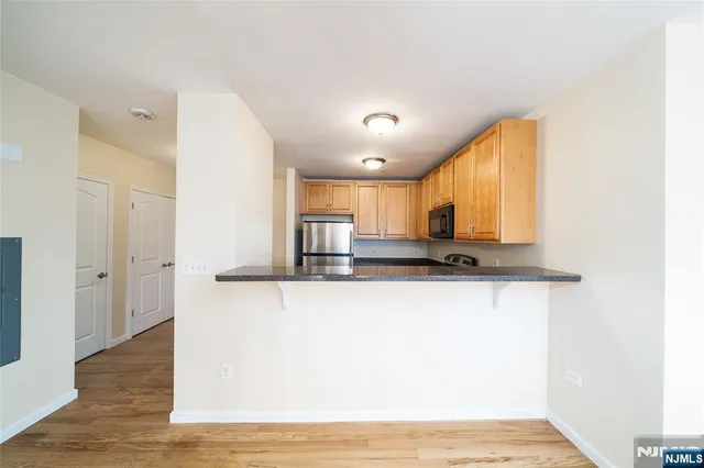 a view of a kitchen with kitchen island a sink wooden floor and a window