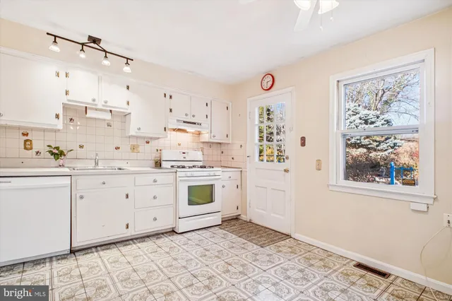 a kitchen with granite countertop white cabinets and white appliances