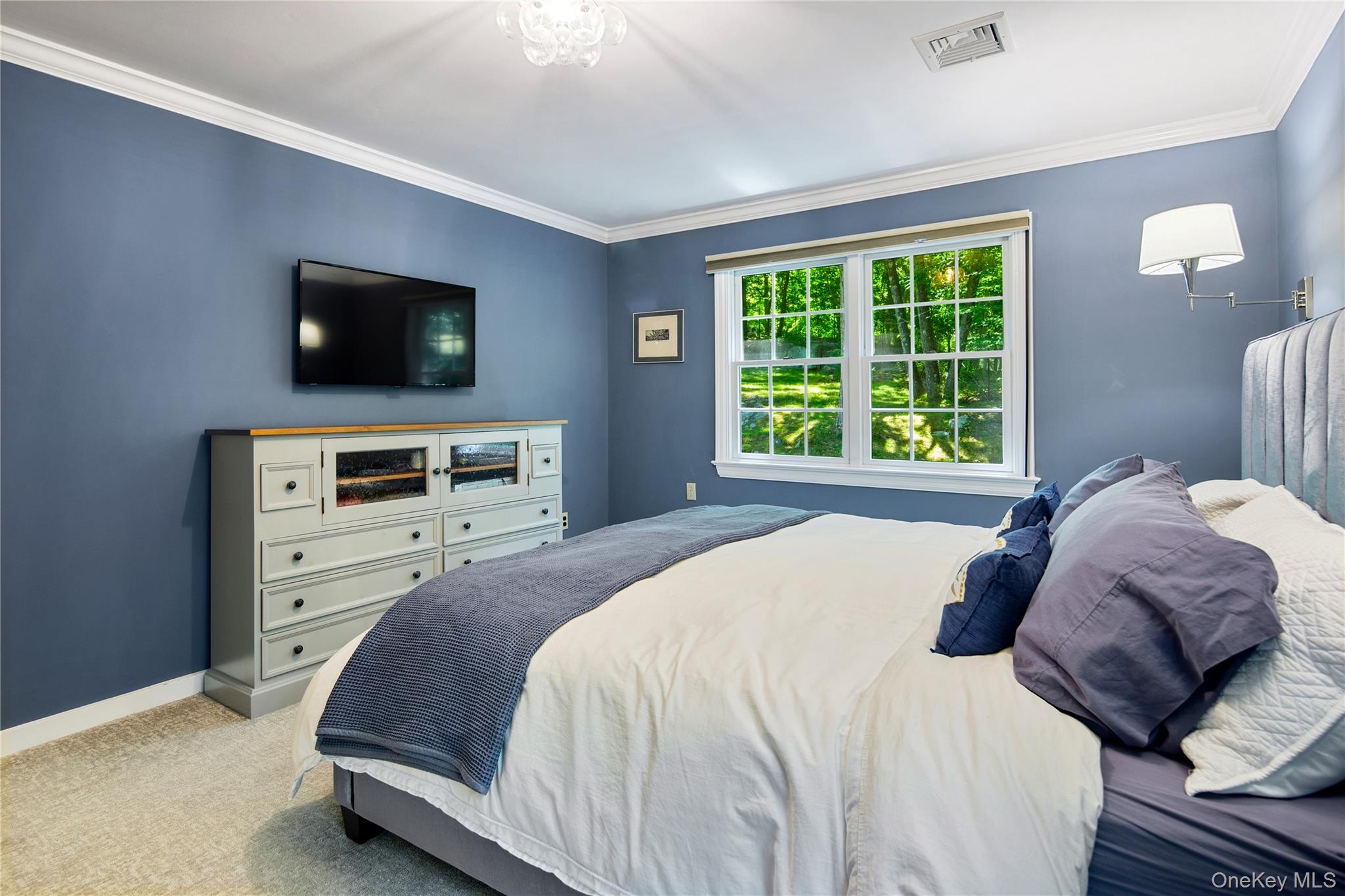 105 Cross Ridge Road Chappaqua, NY 10514 - Photo 28 of 43 Primary bedroom is king size with bedside wall mounted Hanson lamps, crown molding, wall-to-wall carpeting, en-suite primary bath, and walk-in closet