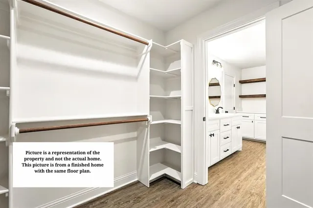 a view of a bedroom with wooden floor & cabinet