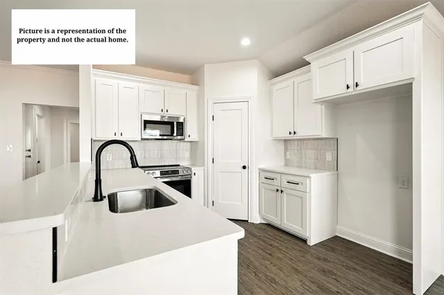 a kitchen with white cabinets stainless steel appliances and sink