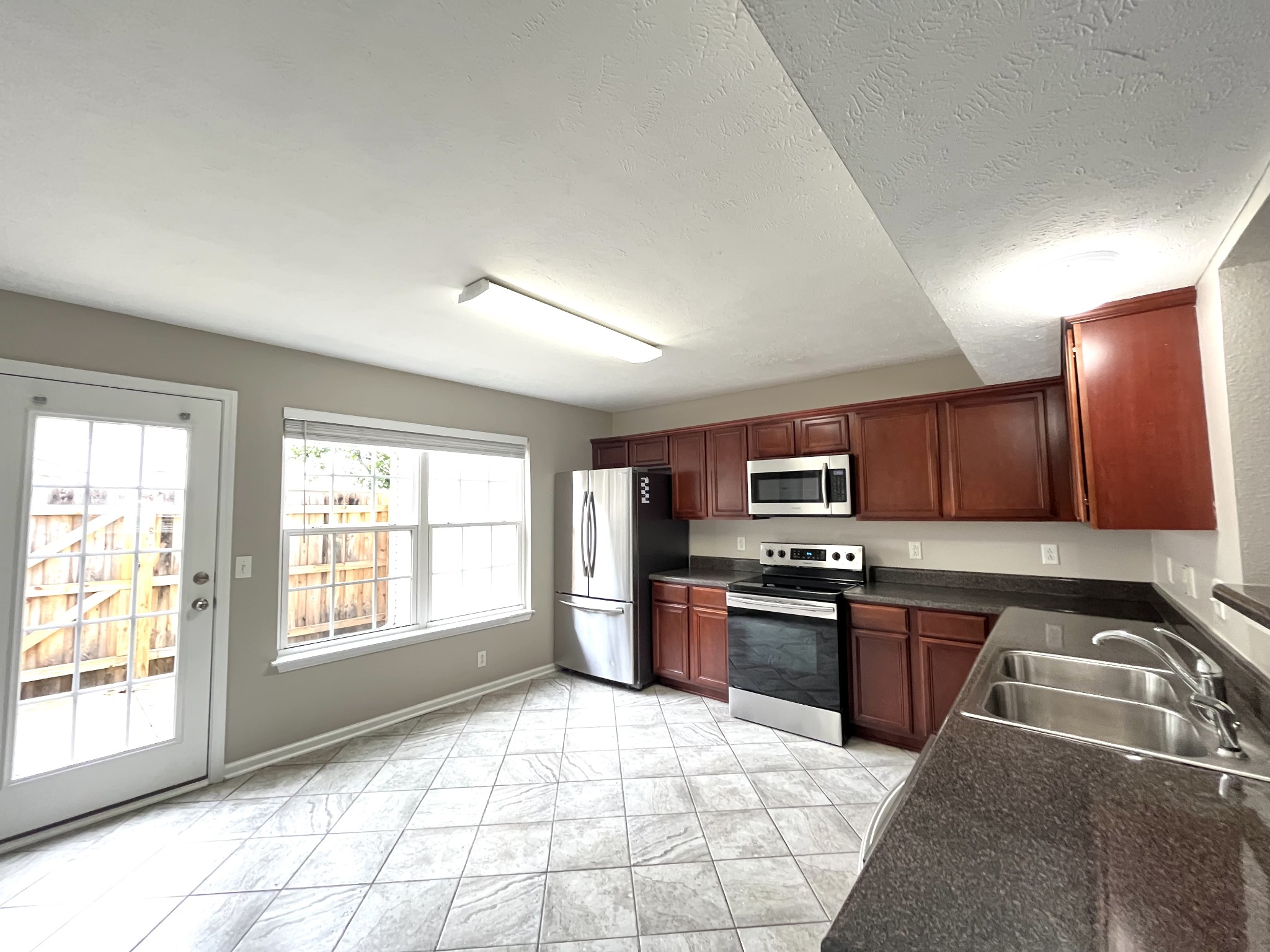 262 Arapaho Drive Murfreesboro, TN 37128 - Photo 5 of 24 a kitchen with granite countertop a stove top oven a sink dishwasher and a refrigerator with wooden cabinets