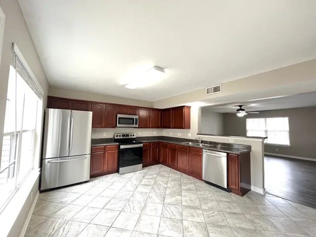 a kitchen with stainless steel appliances granite countertop a stove refrigerator sink and dishwasher