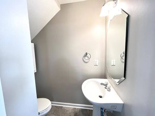 a bathroom with a sink mirror and toilet