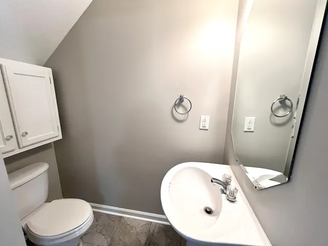 a bathroom with a toilet sink and mirror