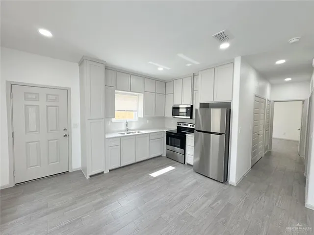 a view of a kitchen with a sink stainless steel appliances and cabinets