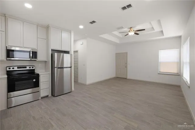 a view of a kitchen with a sink a refrigerator and window