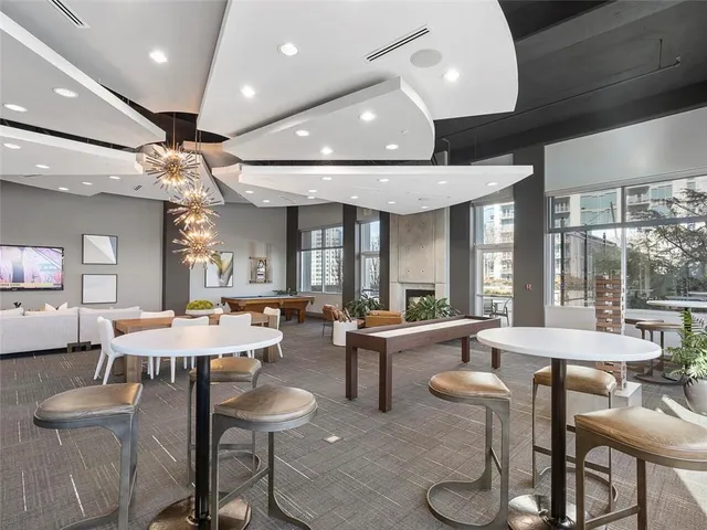 a living room with couches and a large mirror with potted plant