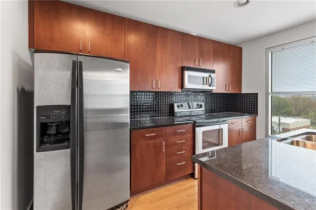 a kitchen that has a sink a counter space and a refrigerator
