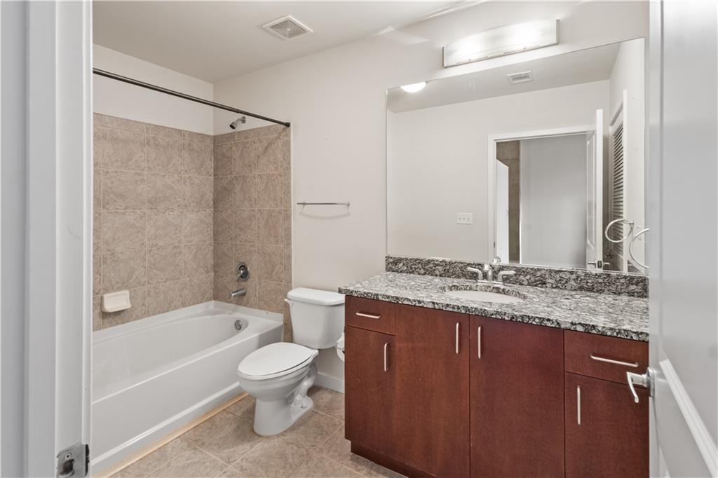 250 Pharr Road Northeast, Unit 514 Atlanta, GA 30305 - Photo 25 of 30 a bathroom with a granite countertop toilet a sink and a bathtub
