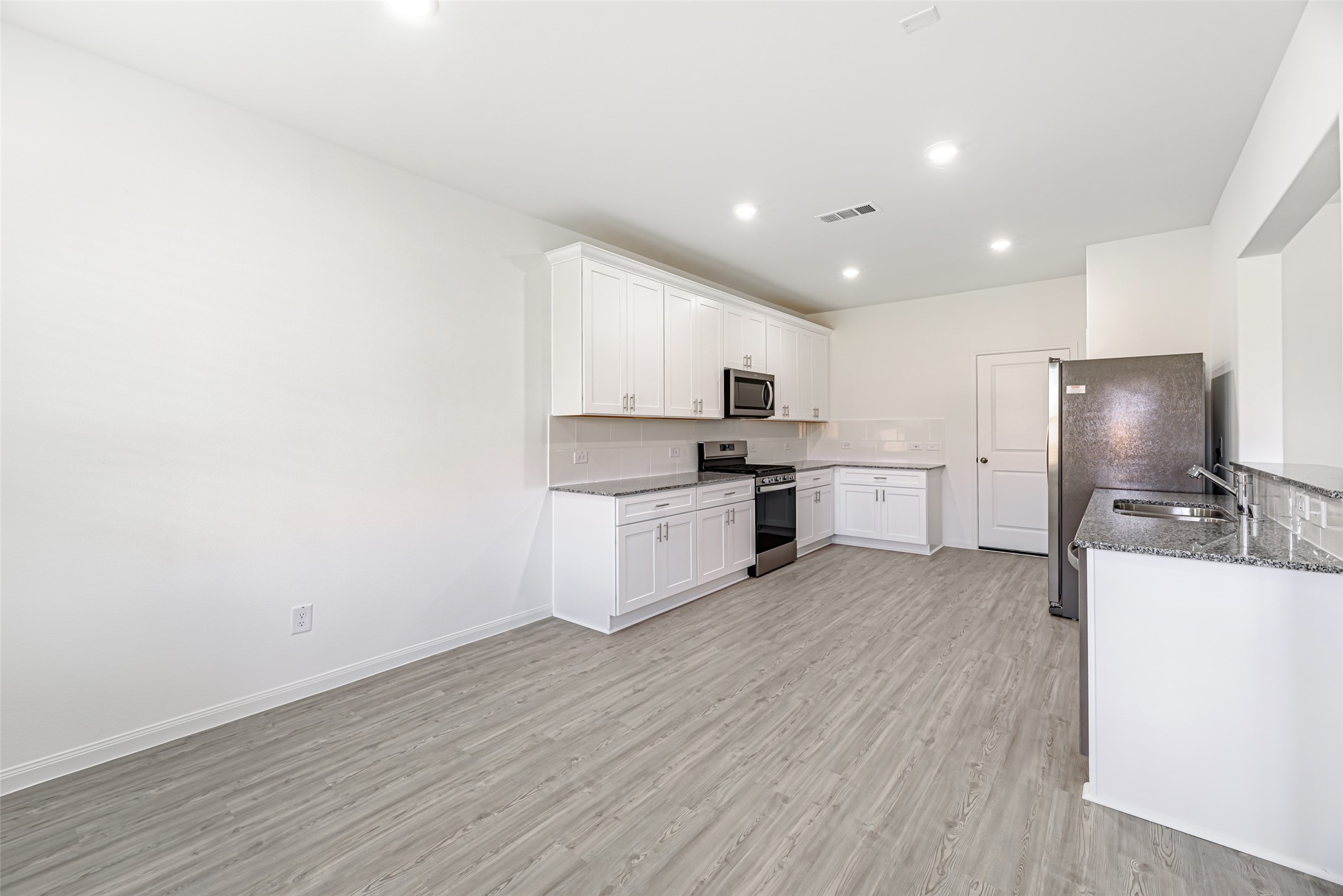 23422 Wagon Cart Road Hockley, TX 77447 - Photo 5 of 28 a kitchen with stainless steel appliances a refrigerator and a stove top oven