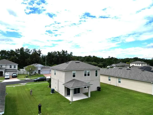 a view of a house with a big yard and large trees
