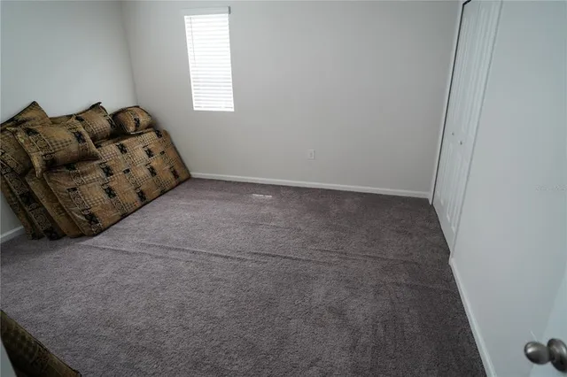 a bed sitting in a bedroom next to a window