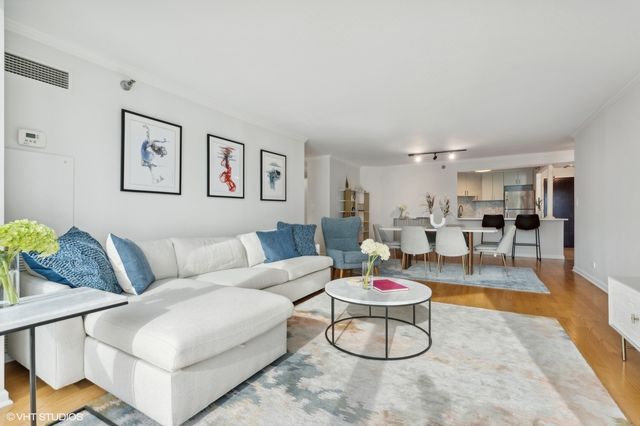 a living room with furniture and kitchen view