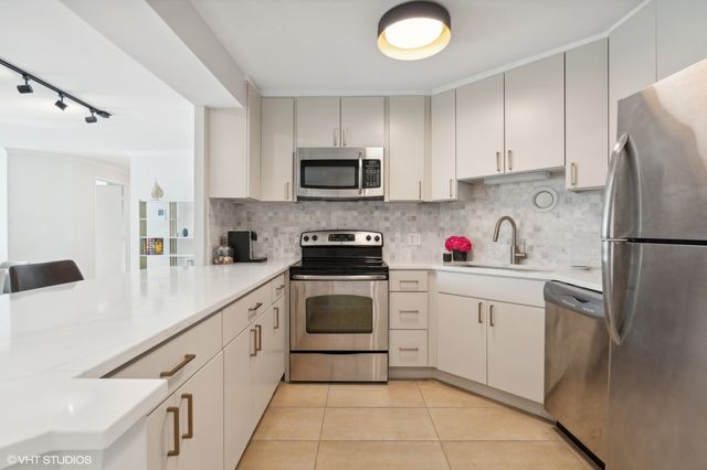 a kitchen with cabinets a sink and white appliances