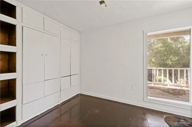 a view of a small space with wooden floor and a window