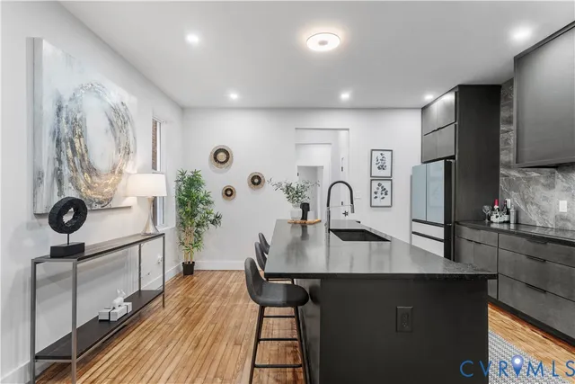 a kitchen with stainless steel appliances granite countertop a sink a stove and a refrigerator