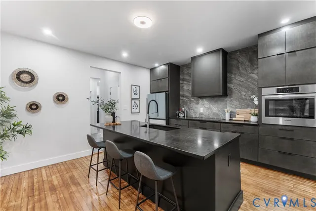 a kitchen with stainless steel appliances granite countertop a sink and a stove