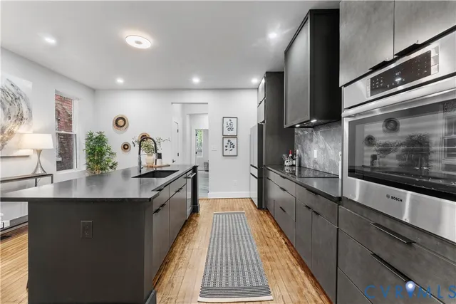 a large kitchen with stainless steel appliances lots of counter space and a sink
