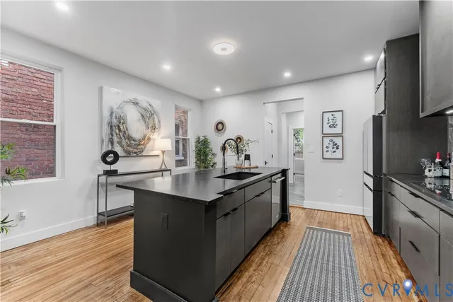 a kitchen with stainless steel appliances granite countertop a sink stove and wooden floor