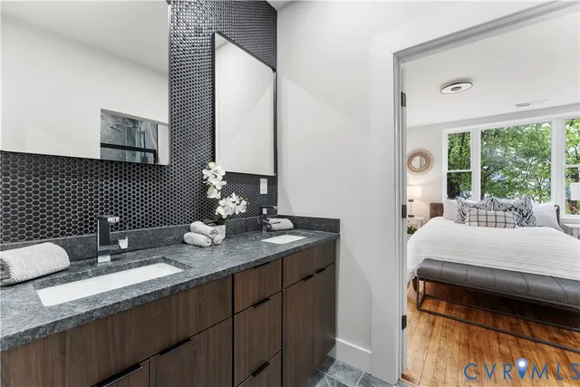 a en suite bathroom with a granite countertop sink and a mirror