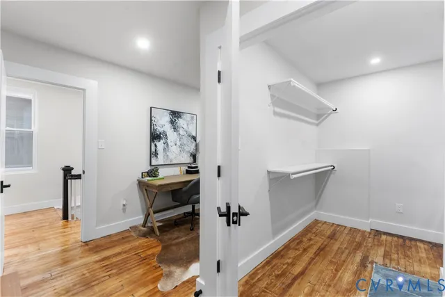 a view of a hallway with wooden floor and workspace