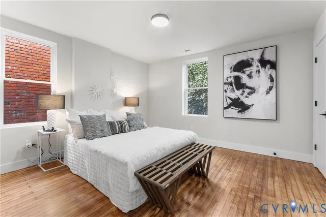 a bedroom with a bed and a painting on the wall